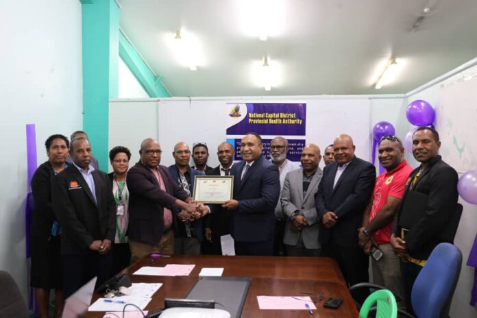 Caption: Deputy Secretary strategy and governance Dominic Ira presents a public sector audit program certificate to NCD PHA chief executive officer Dr Robin Oge as authority staff and Finance Department officials look on.