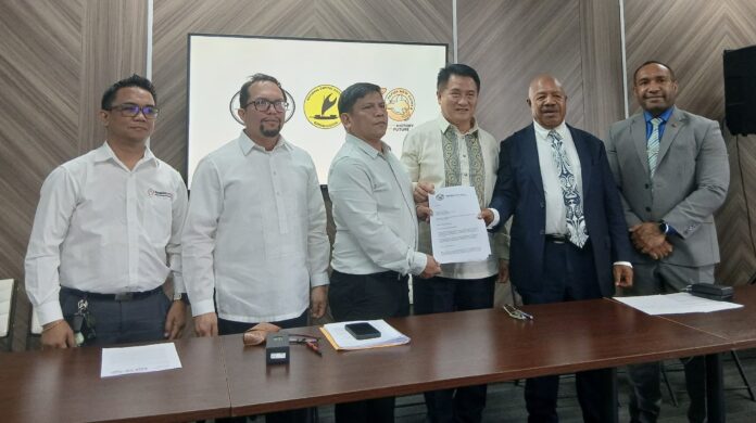 (R-L) NCDPHA CEO Dr Robin Oge, NCD Governor Parkop, Philippines Ambassador Edgar Tomas Auxilian, FAPNG president Jonathan Plasabas sign the partnership agreement as officials look on. Picture by Sepkolin Walne.