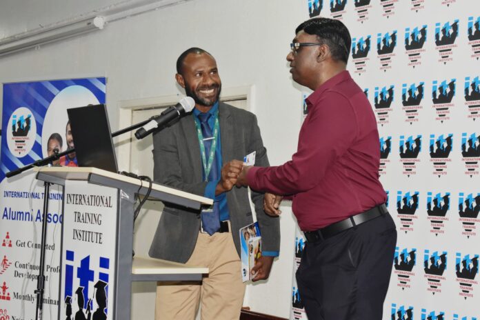 The Chairman and Co-founder of International Training Institute(ITI) Senthil Kumaran Sentheyal(right) officially launching and Presenting the ITI Alumni Membership card to Mr Milton Hompimie Neinguma(left) one of the first two recipients of the ITI Alumni Membership Card during the 2nd Alumni Meeting in Port Moresby Photo supplied by ITI Media